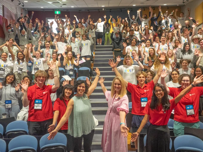 Everyone with their arms up and smiling at the camera!