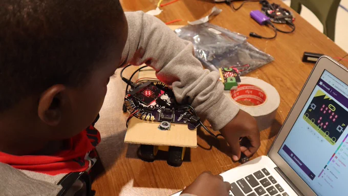 Young boy building a small robot. 