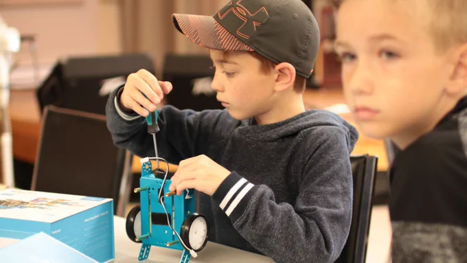 Young boy building a small robot. 