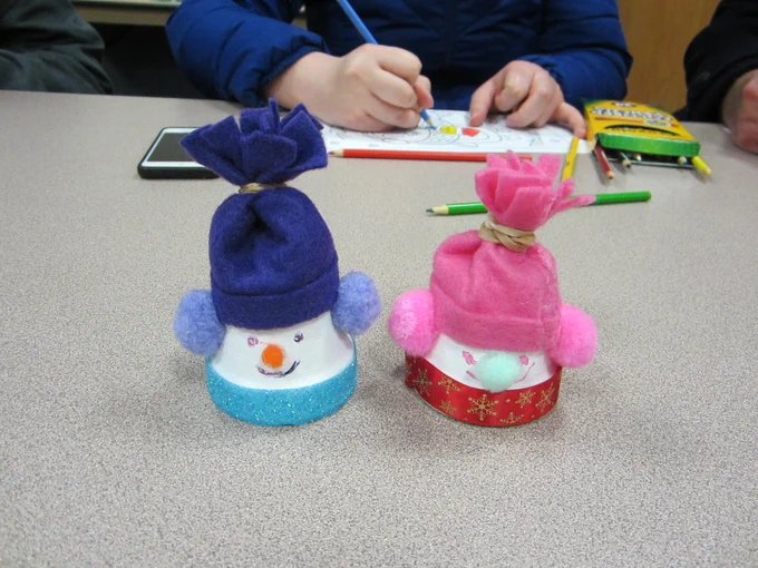 Two snowmen, one in blue and one in pink