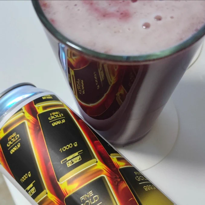 Can of beer laying next to a full glass of red beer.