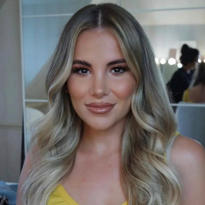 Close-up of Georgia Kousoulou, wearing a yellow top and smiling.