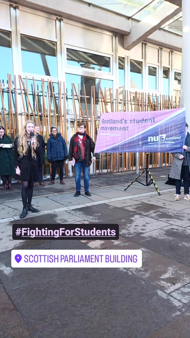 A photo of NUS Scotland President Ellie Gomersall speaking in front of Scottish Parliament next to an NUS Scotland banner.