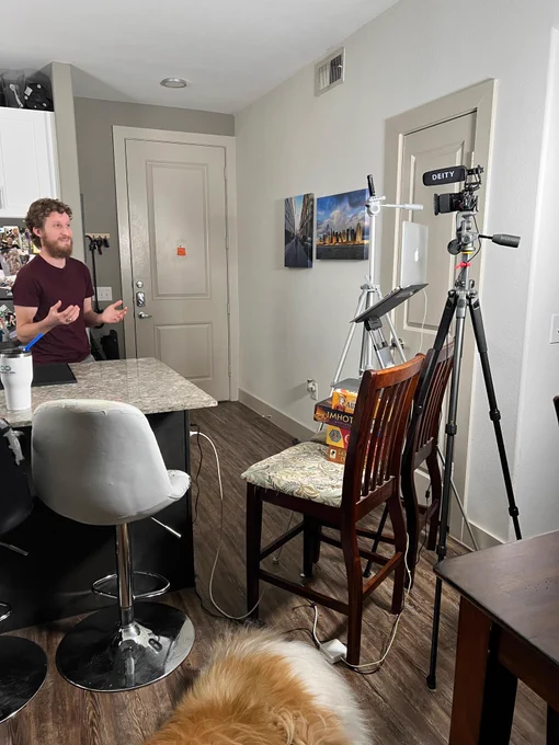 a video filming setup in an apartment kitchen with a collie dog laying nearby