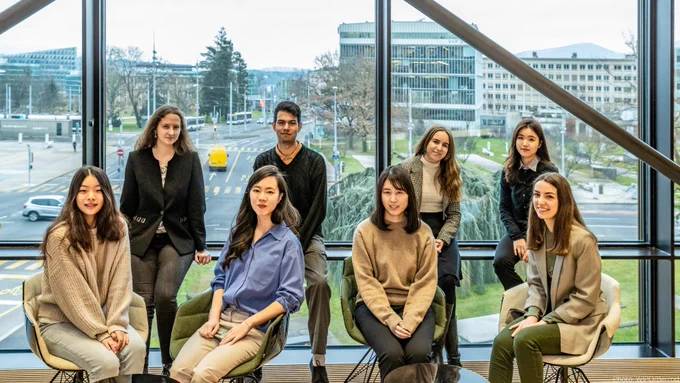 A group of recent graduates who are taking part in the PCT Fellowship Program at the World Intellectual Property Organization are seen sitting together in the workplace.