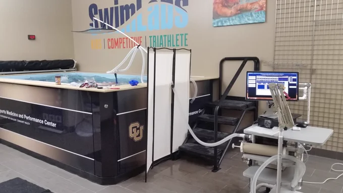 Picture of swimmer in endless pool and hoses running to metabolic cart