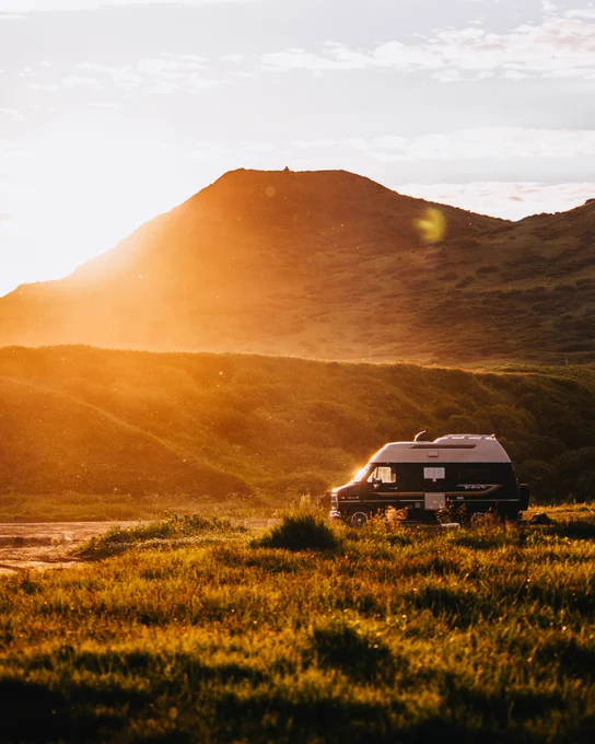 a warm sunset photo of a van on the coast, camping. Photo taken by Alaskan photographer, Ellen Carty
