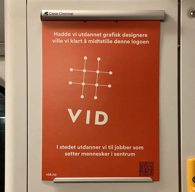 Plakat med logoen til VID plassert på skrå og til venstre side av plakaten. Med teksten "Hadde vi utdannet grafiske designere ville vi klart å midtstilte denne logoen. I stedet utdanner vi til jobber som setter mennesker i sentrum"