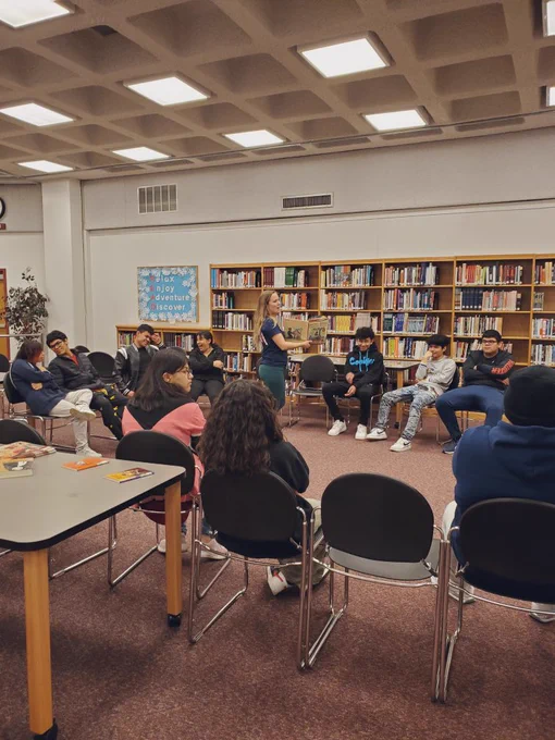Ms. N reading a book aloud while students listen and enjoy