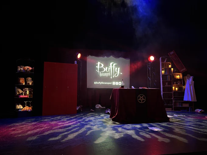 Photo of the stage of buffy revamped. There’s an altar in the middle, a shelf on each side in the background and a set of lockers