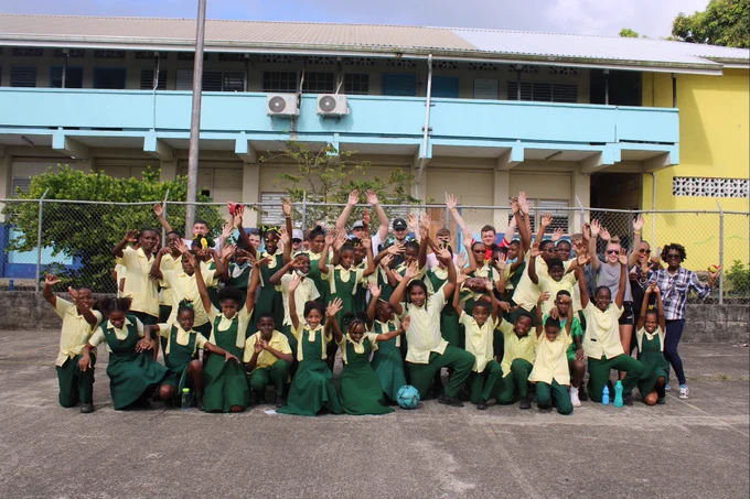 A photo of all of the DN Colleges Group students and all of the primary school class posing for a group photo.