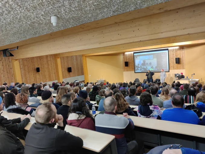 Back of the room view of the lecture theatre full of people listening to the trade union representatives 