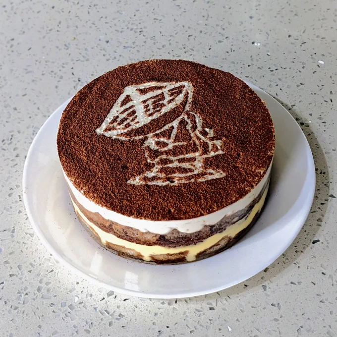 A circular price of tiramisu. Cocoa powder is on top and outlines the shape of a radio dish