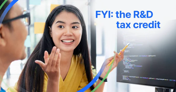 Text says FYI: the R&D tax credit. There is a woman pointing at a screen with code and discussing it with another colleague.