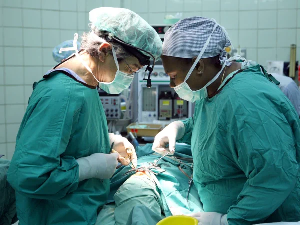 An interplast team doctor and a NRH doctor operating on a patient back in 2015