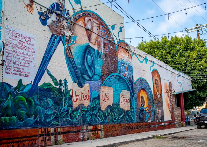 A colorful and detailed mural of various Black leaders. Visible text reads "United We Stand".