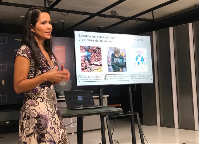 Investigadora Alejandra Caqueo exponiendo una diapositiva en la que se ven textos e imágenes