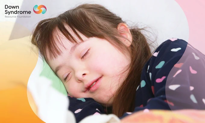 brown haired white girl with Down syndrome wearing navy pajamas with hearts on them, asleep in bed