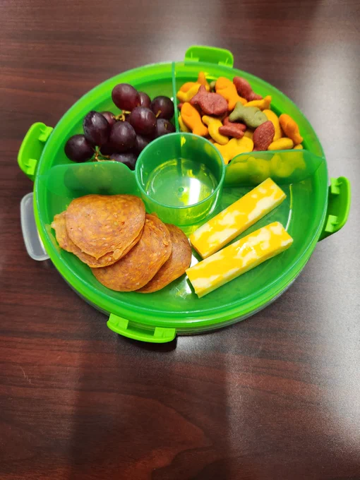 Tupperware with goldfish cheese sticks and pepperoni.