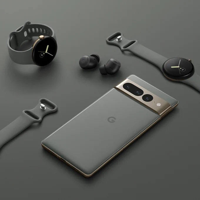 The Google Pixel 7 Pro in Hazel, Pixel Buds Pro in Charcoal, and Pixel Watch in Champagne Gold case / Hazel Active band on a gray surface.