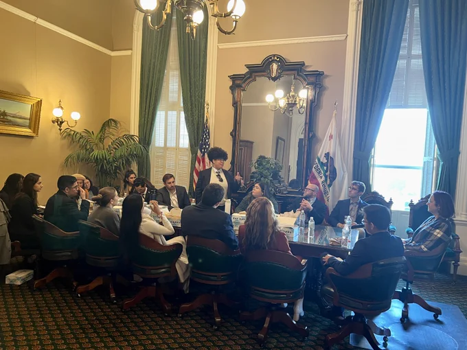 Assemblymember Laura Friedman and the Assembly Fellows sitting around a large conference table.