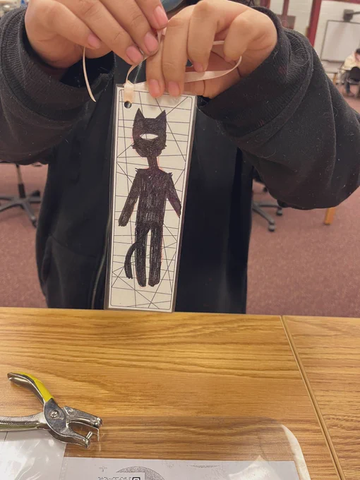 A customized image drawn by a student, on a finished bookmark with pink ribbon