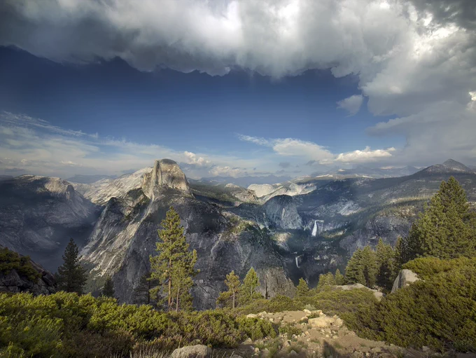 A panoramic view of Yosemite National Park overlooking mountain ridges and a sparse forest. Credit: Library of Congress, Public Domain