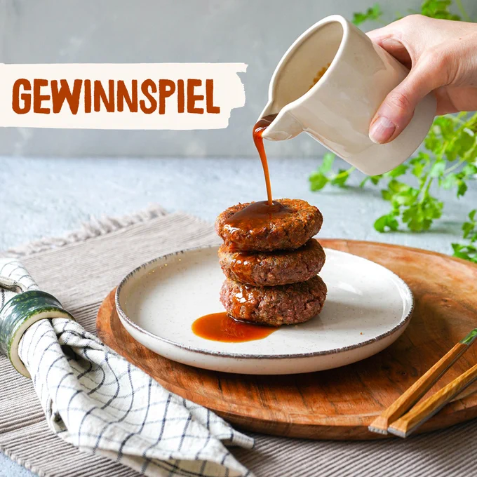 Auf dem Bild sind vegane Frikadellen, die mit der Bratensauce übergossen werden, zu sehen.