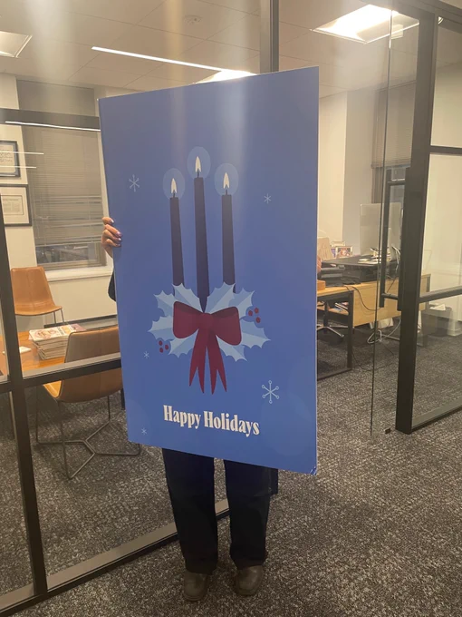 Person delivering giant holiday card to Washingtonian's CEO. 