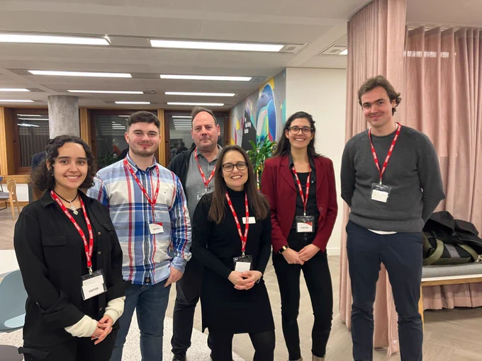 The event team of six people smile in a group photo in the Turing offices