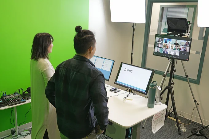 Our SET-BC OTs Pearl and Wilson hosting an online workshop in our green studio, with 3 monitors set up in front of them