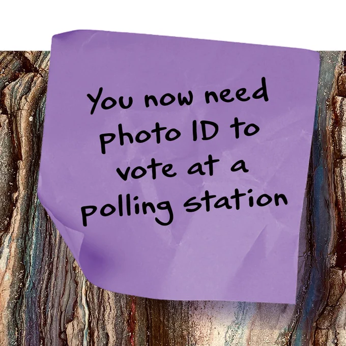 Image is of a purple post-it note on a wooden table with the text "You now need photo ID to vote at a polling station".