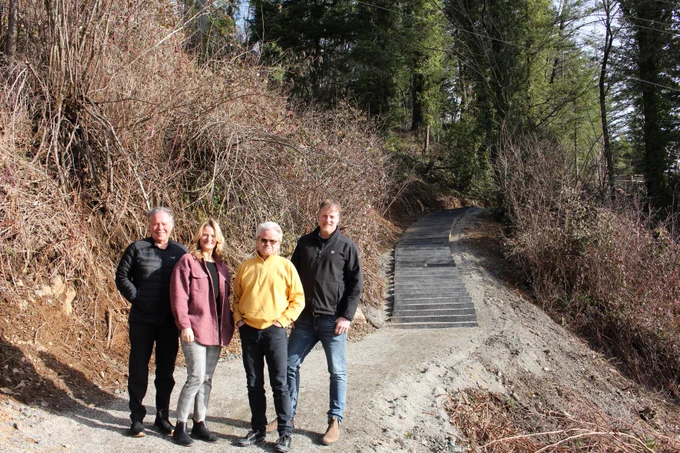 Councillors Mercer and Read, Mayor Popove, and Councillor Kloot stand on the trail in front of Little Mountain Stairs.