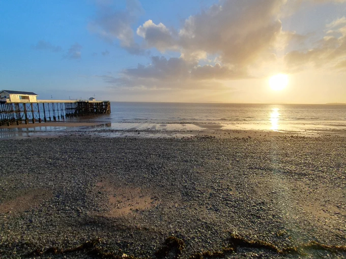 Sunrise over a beach with a pier
