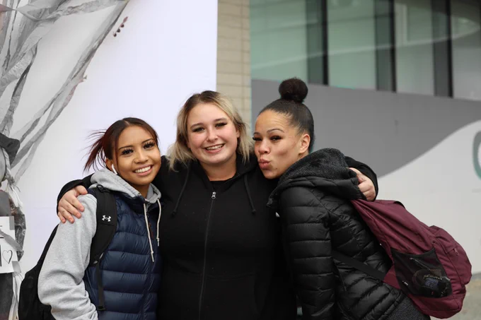 Three students posing for the camera and smiling. 