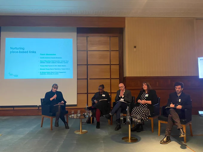 Four speakers sitting on chairs, alongside the discussion Chair, with a slide in the background entitled 'Nurturing place-based links'