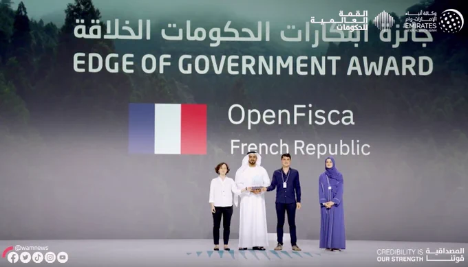 Large stage of the Edge of Government Award: Project OpenFisca from French Republic is distinguished. People hold the award.