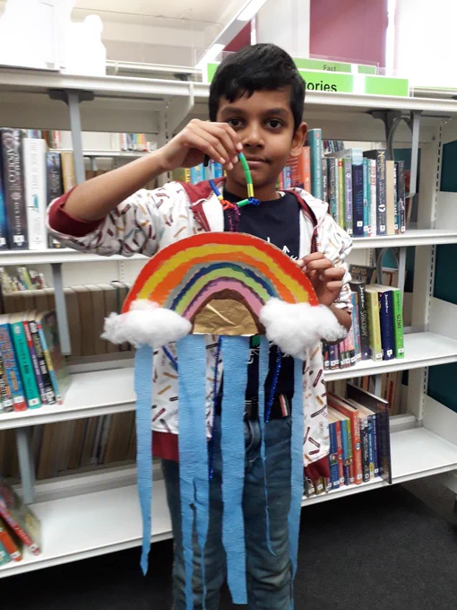 Boy holding his rainbow mobile