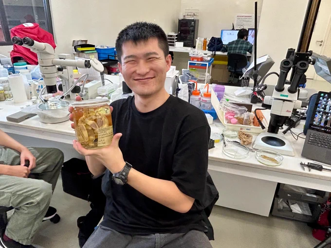 Photo of Mr Hiroki Nakajima posing with a jar containing specimen. 