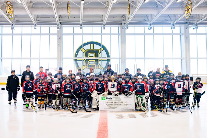 Charlie Coyle, the Bruins youth hockey crew, and Brookline Youth Hockey pose for a photo during a check presentation after the clinic.