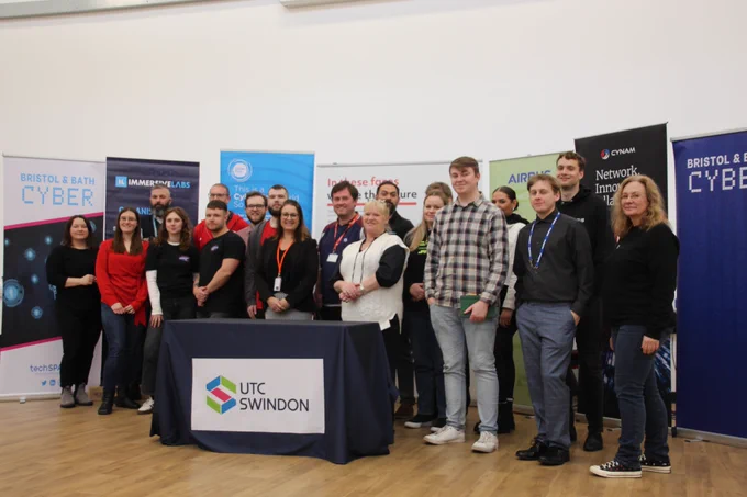 Members of the companies taking part in Cyber Horizons schools project stood in front of marketing banners.