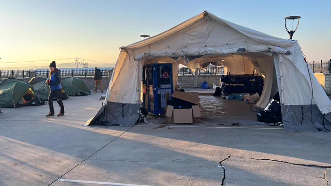 13 February 2023, southern Turkey. Members of the UK Emergency Medical Team construct a tented field clinic next to a hospital that was damaged in the Turkey earthquake.