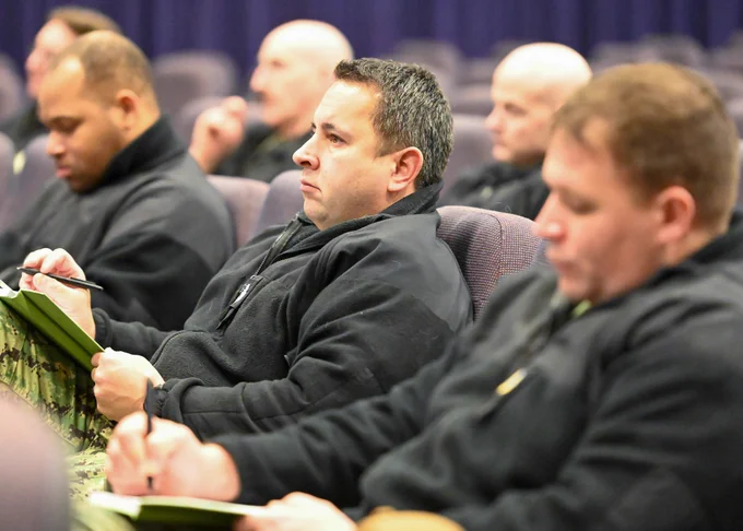 Senior leaders stationed at Naval Air Station Whidbey Island, Washington, listen to Sgt. Maj. Michael Hensley, command senior enlisted leader of the United States Naval Community College, on February 7, 2023.