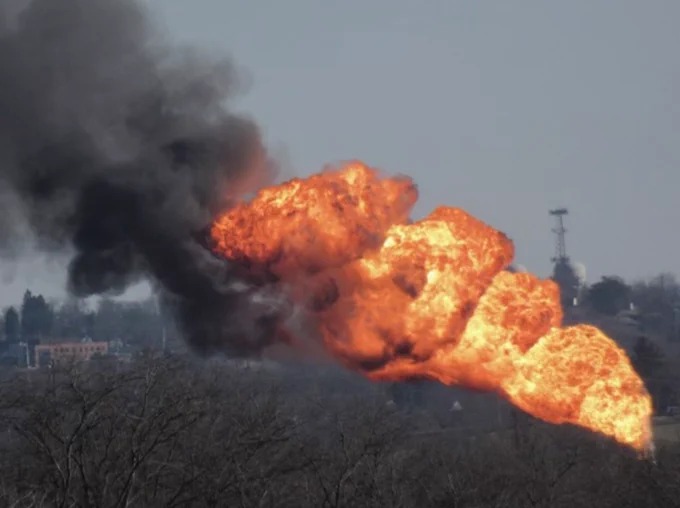 Picture of massive flare with black smoke coming from the shell plant you can see trees in the foreground