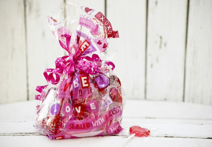 A bag of pink valentines chocolate and a lollipop