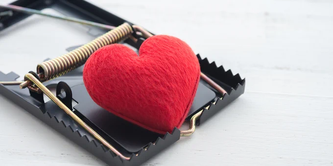 A small, red heart-shaped cushion in a mouse trap.