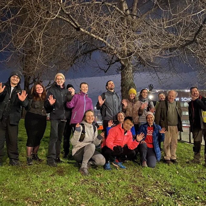 15 volunteers with jazz hands posing for an image after planting 200 trees