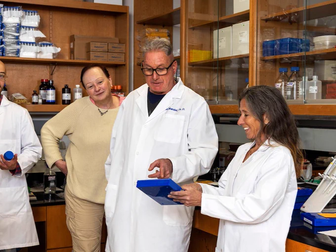 Dr. Johnston and Dr. Ron Mandel with a box of microscope slides for pathology samples.