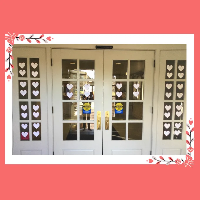 Image of the library doors covered in paper hearts from students