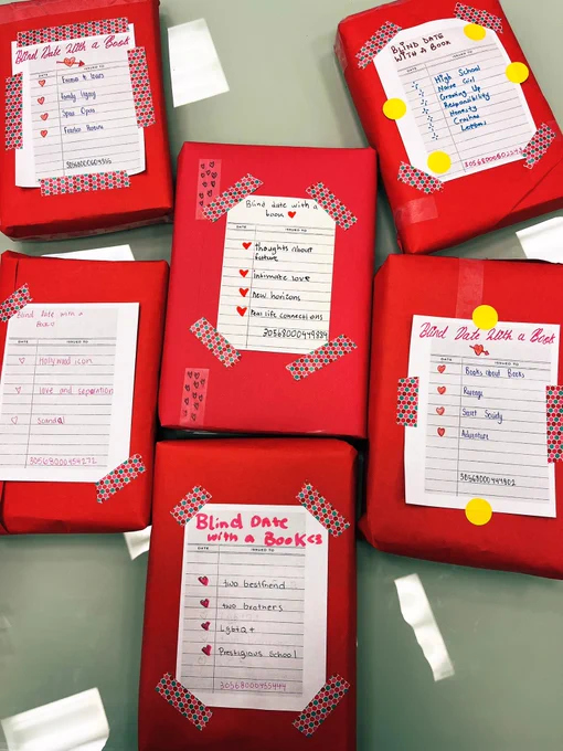 Books wrapped in red paper with brief descriptions for a Blind Date